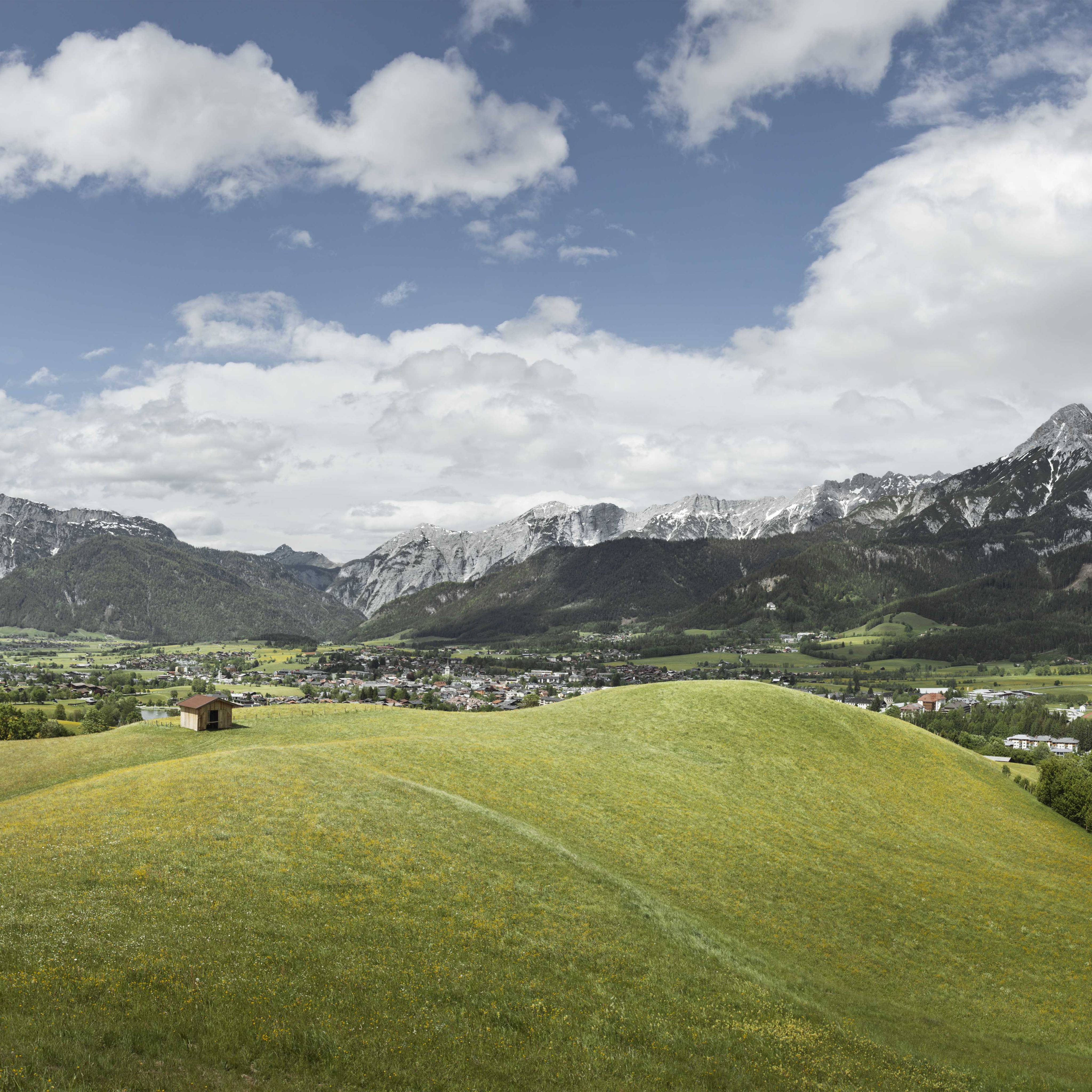 Landschaftsbild von Saalfelden - Berge, Wiesen und Wolken