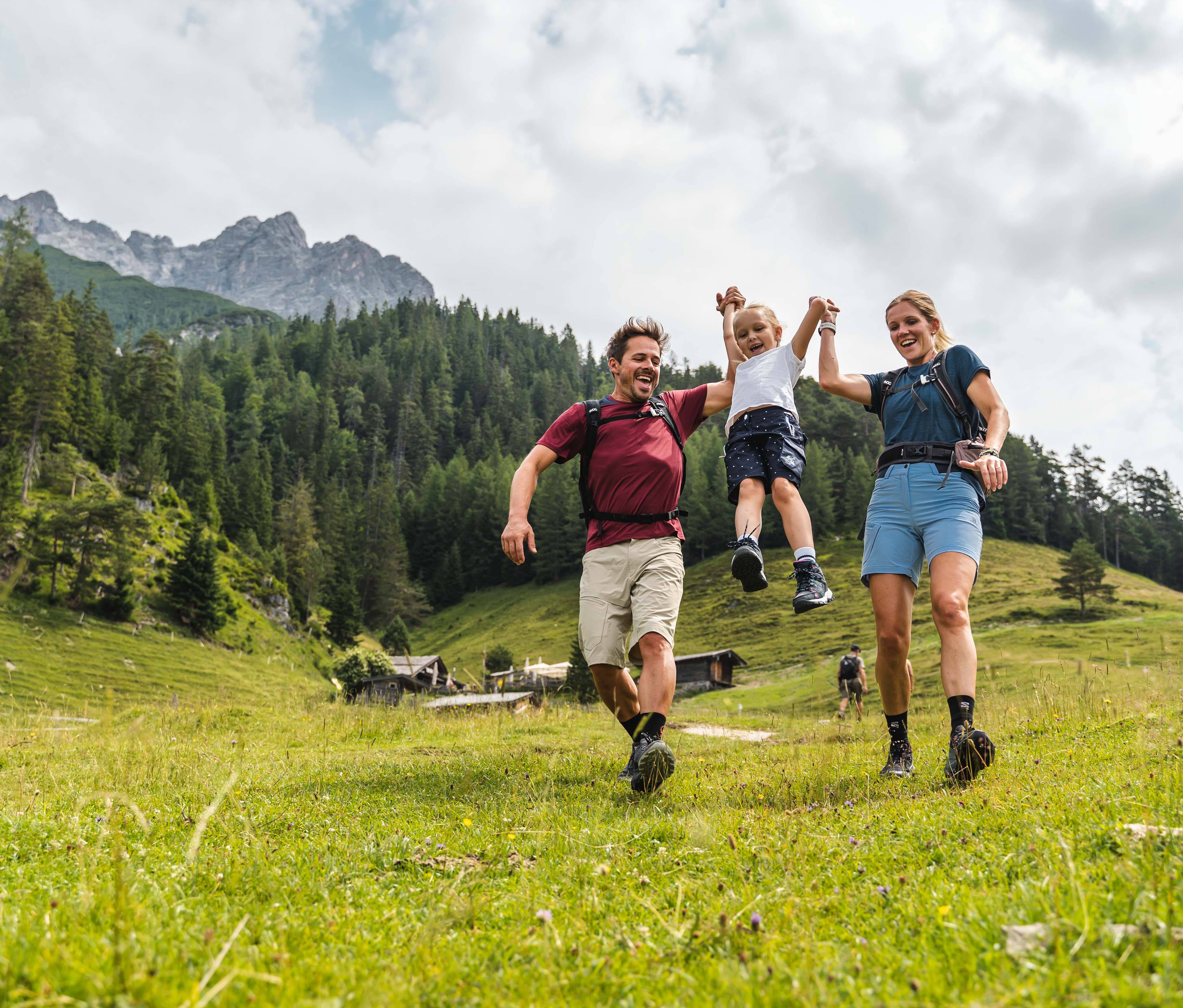 Wanderfamilie haben Spaß auf einer Bergwiese