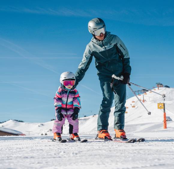 Kinder Ski in Saalfelden - Vater hilft seinem Kind beim Skifahren