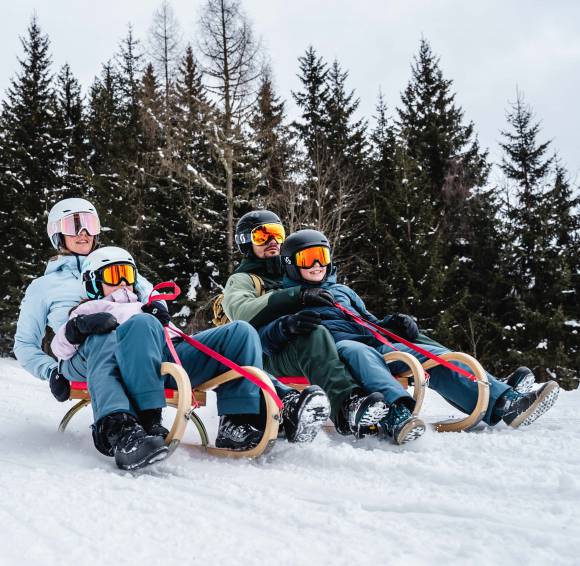 Familie beim Rodeln in Österreich