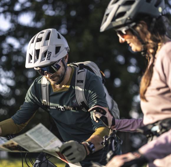 Biker schauen auf eine Karte zur Orientierung