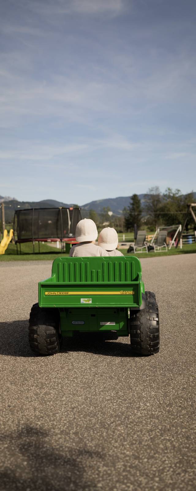 Kinder fahren im Spielzeugauto entlang eines Wegs