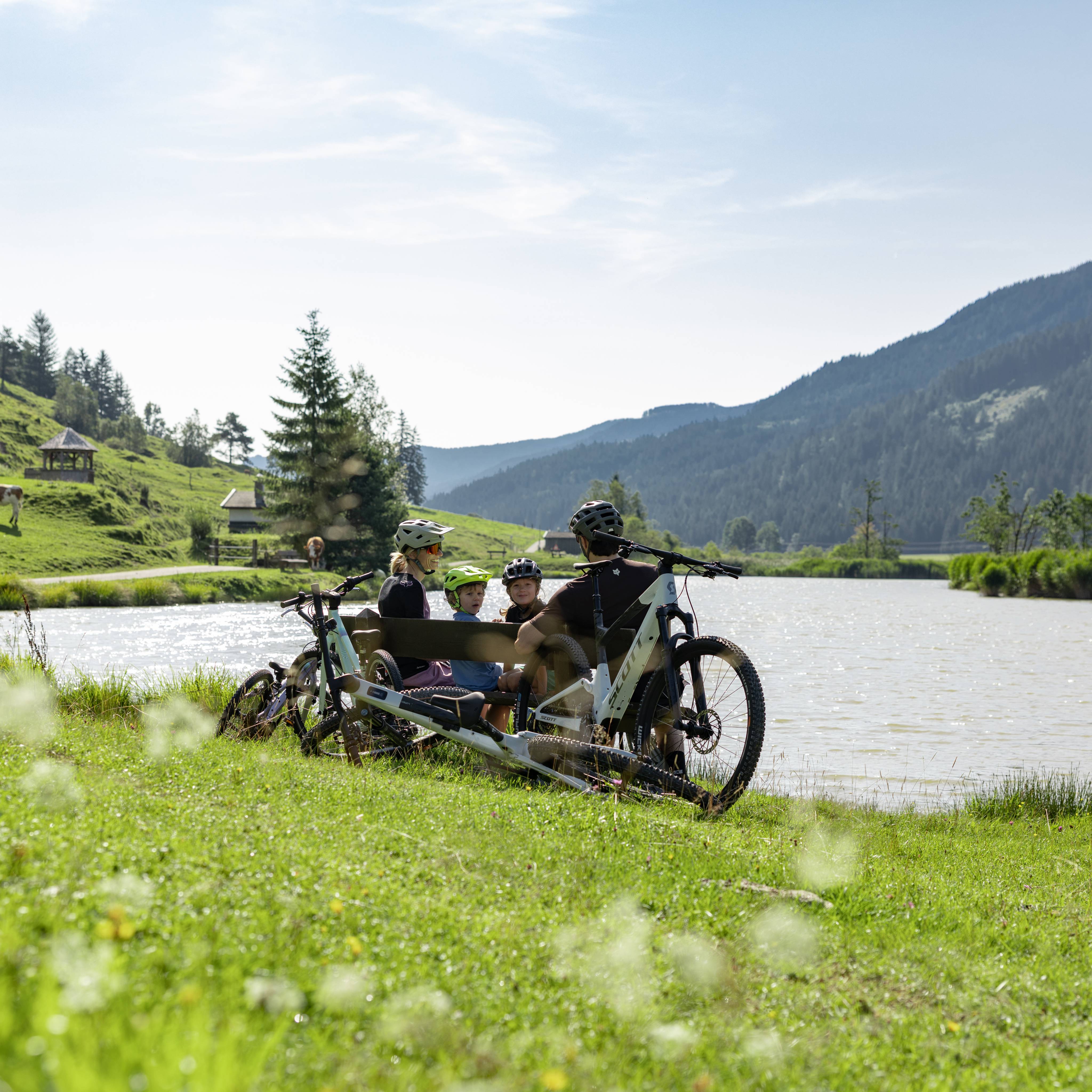 Biker machen eine Pause an einem Bergsee in Leogang